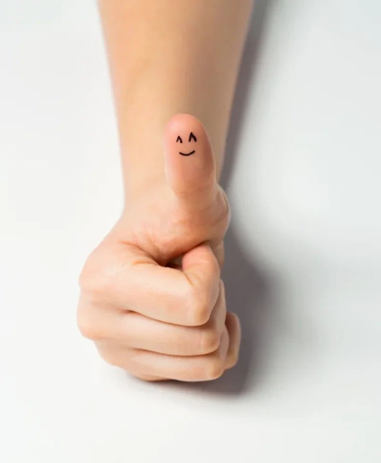 gesture-success-body-parts-concept-close-up-woman-hand-showing-thumbs-up-with-smiley-face Image description